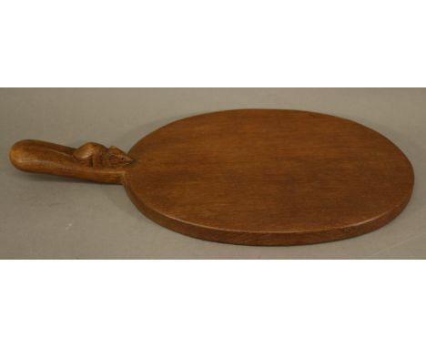 Workshop of Robert Thompson of Kilburn, North Yorkshire A "MOUSEMAN" OAK CHEESE BOARD of oval form the handle with carved mou