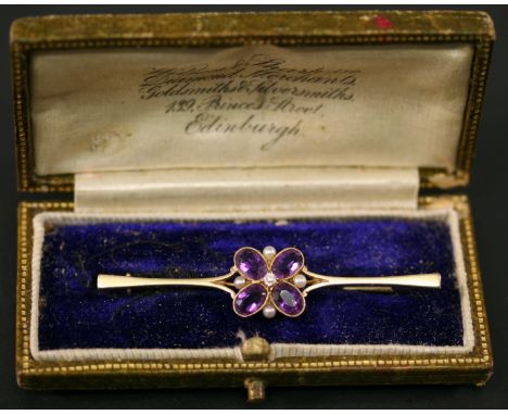 A YELLOW METAL PEARL, DIAMOND AND AMETHYST BROOCH, the slender bar with central arrangement of stones in a stylised flower he