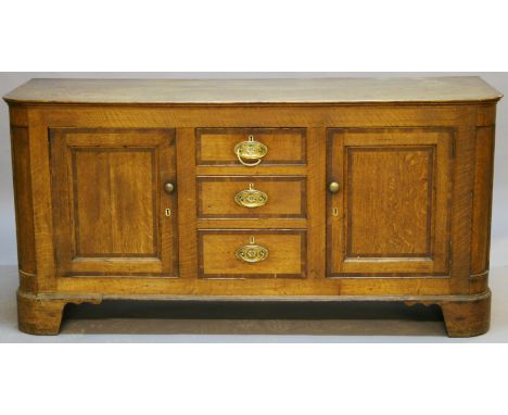 A GEORGE III OAK DRESSER BASE of oblong form with rounded front corners, over three central crossbanded drawers and two flank