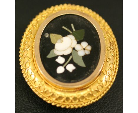 A YELLOW METAL AND PIETRA DURA BROOCH of oval form, the mosaic formed as flowers in a surround ornamented with tracery, butto