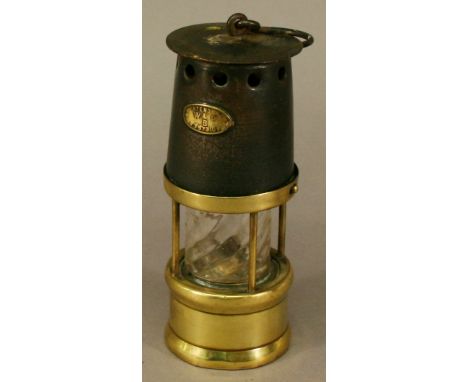 A MINIATURE BRASS AND STEEL MINERS' LAMP marked W&PB patent number 23573109. 15cm(h) CONDITION: Some corrosion, slightly loos