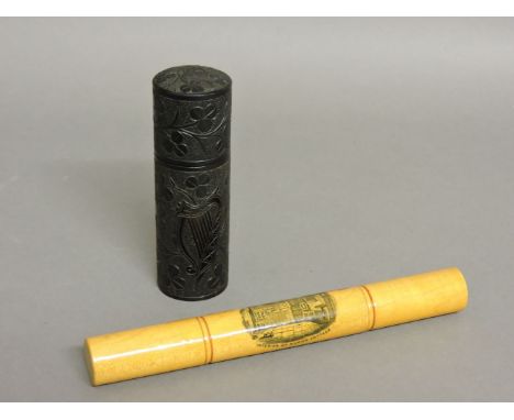 An Irish turned wood needle case, probably bog oak, carved with shamrocks and a harp, 10cm high, and a Mauchline ware needle 