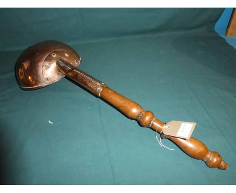 A 19th century copper Ladle, 22cm diameter with 50cm turned wooden handle 