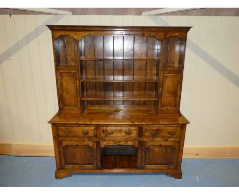 A good reproduction oak 18th century Dresser, ogee moulded cornice above three central shelves, flanked either side by a nich