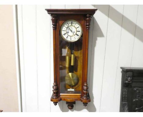 A late 19th century walnut cased Vienna style Wall Clock, cream enamel two part dial in brass ring with Roman numerals, ename