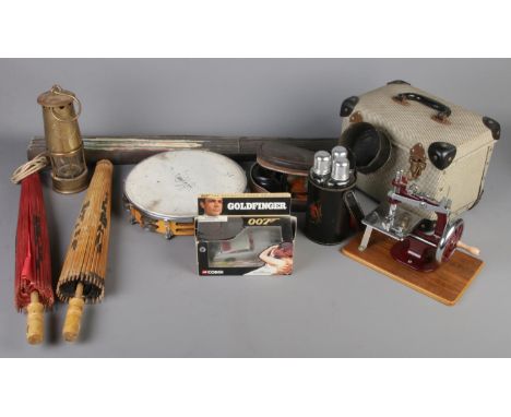 A box of collectables. Includes miner's lamp converted to electric, Essex miniature sewing machine, Beefeater travel set, box