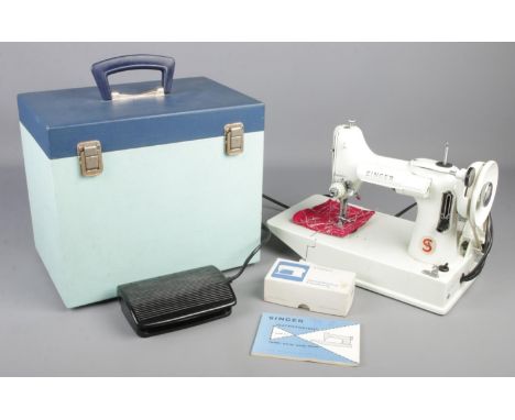 A 1960s white model Singer Featherweight 221K sewing machine with original case and manual.  