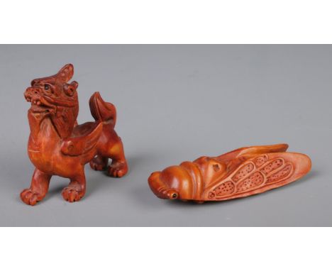 A pair of Japanese carved netsuke figures in the form of a foo dog and a cicada insectFoo dog height 5.5cmCicada length 7.5cm