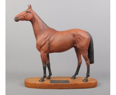 A connoisseur model by Beswick of Red Rum, raised on wooden plinth. Height: 32cm.  