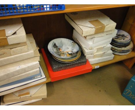 A shelf of Collector's plates, boxed.