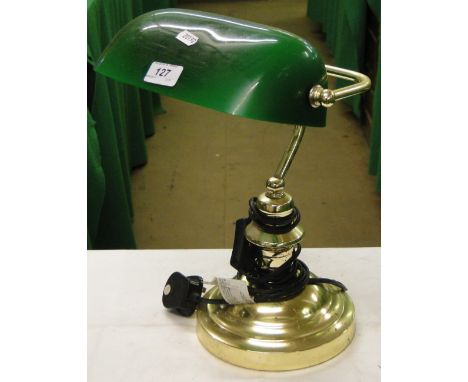 A brass adjustable desk lamp with green glass shade