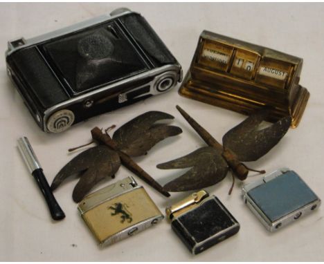 Vintage camera, perpetual calendar, cigarette lighters and dragonflies.