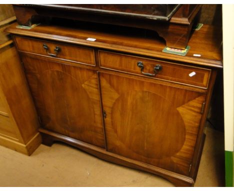 A reproduction mahogany sideboard of small size with 2 frieze drawers, cupboards under on bracket feet.