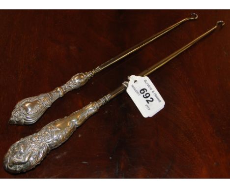 2 large embossed silver handled button hooks.