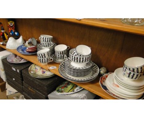 A shelf including a teaset, Imari plate and glass clowns.