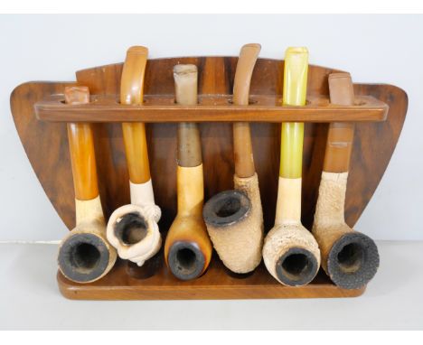 Five carved Meerschaum pipes, one other and a wooden pipe rack for six pipes