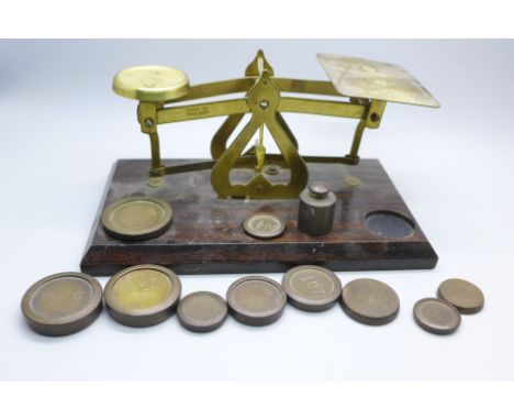 A set of brass and wooden balance scales marked ‘made in England’ and a collection of weights 