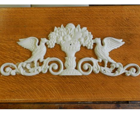 A cast iron white plaque, having central urn with fruits, flanked by two eagles above scrolling foliage, L.71cm, together wit