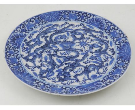 A 19th century Chinese blue and white plate, decorated central circular panel depicting dragons chasing a flaming pearl. 