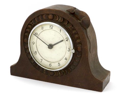 Robert Mouseman Thompson (1876-1955): An English Oak Mantel Clock, 1930's, the adzed circular case with chip carving, set wit