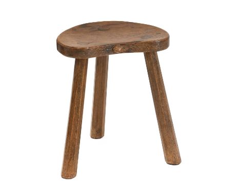 Workshop of Robert Mouseman Thompson (Kilburn): An English Oak Kidney Shaped Calf Stool, on three octagonal legs, with carved