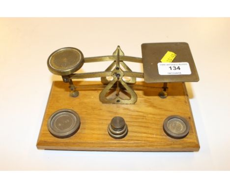 A set of brass postal scales and weights