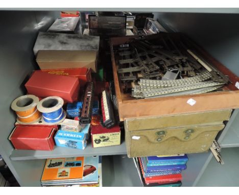 A shelf of 00 gauge and 0 gauge Track including Marklin, two 00 gauge Carriages, along with empty Marklin, Triang, Hornby and
