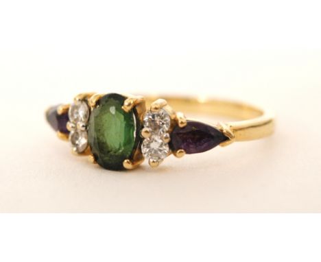 A modern 18ct hallmarked green tourmaline, diamond and amethyst seven stone ring, central tourmaline flanked by pairs of diam