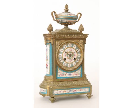 A late 19th Century French gilt metal and porcelain mantle clock, the case with an urn-shaped finial above the dial centred b