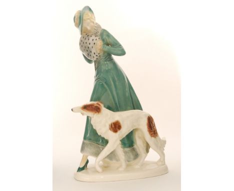A 1930s Art Deco model of a lady dressed in a long green coat holding an ermine fur muff walking with a Borzoi dog, unmarked,