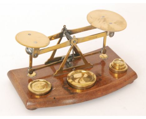 A set of Victorian postal scales in brass on an oak base, complete with weights.
