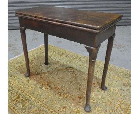 A George II mahogany rectangular card table, the fold over top over a plain frieze, the hinged rear legs with folding concert