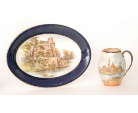 A Royal Worcester oval dish decorated with a hand tinted scene of Warwick Castle within a blue border edge, puce mark with da