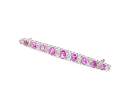 A RUBY AND DIAMOND LINE BROOCH set in white coloured metal with nine graduated rubies combined approx 1.5ct and eighteen anti