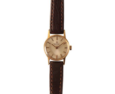 OMEGA: A LADY'S 18CT GOLD WRISTWATCH with manual wind movement, the silver dial with gold baton numerals and gold hands, circ