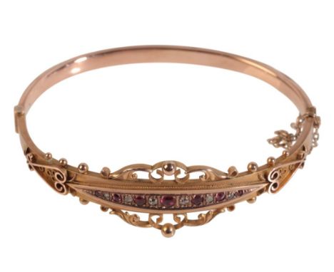 A DIAMOND AND TOURMALINE GOLD BANGLE hallmarked 375, set with six rose cut diamonds 0.08tcw and seven deep pink tourmalines,d