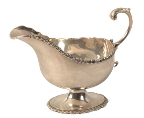 AN EDWARD VII SILVER SAUCE BOAT by Haseler Brothers, London 1902, with leaf capped handle and gadrooned mounts, 12.5cm high, 