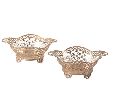 A PAIR OF EDWARD VII SILVER OVAL TWO HANDLED BASKETS by William Comyns, London, 1907, with cast ribbon handles, pierced sides