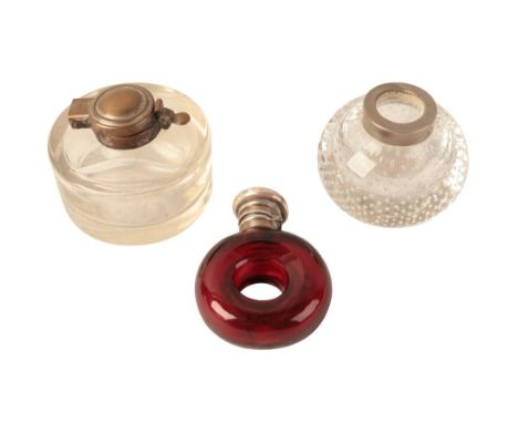 A VICTORIAN WHITE METAL TOPPED RUBY GLASS SCENT BOTTLE with circular body, 8cm high, the lid engraved and with internal clear