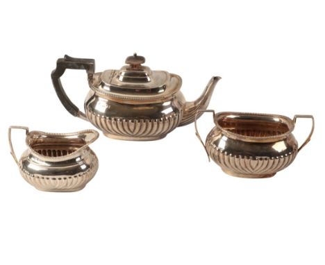 A LATE VICTORIAN SILVER THREE PIECE TEA SERVICE by Atkin Brothers, Sheffield 1894, with squat part gadrooned bodies, comprisi