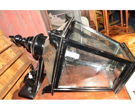 A REFURBISHED BLACK PAINTED WROUGHT IRON AND STEEL WALL MOUNTED LANTERN, of square tapering form with electrical wiring