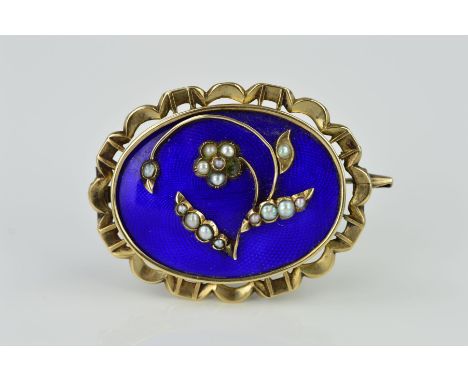 A MID VICTORIAN GOLD MEMORIAL BROOCH, blue enamel inlaid with floral seed pearl detail, oval shape with scalloped edge measur