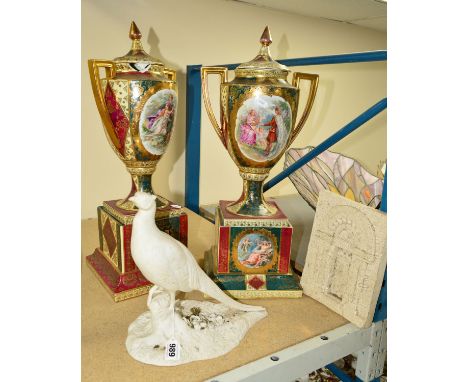 A PAIR OF CONTINENTAL CERAMIC PEDESTAL URNS WITH TRANSFER PRINTED CLASSICAL SCENES, enamel and gilt decoration (some damage),