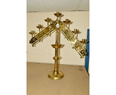 A VICTORIAN BRASS GOTHIC ECCLESIASTICAL SEVEN LIGHT CANDELABRUM, with ratchet fittings to both arms to adjust heights, on a k