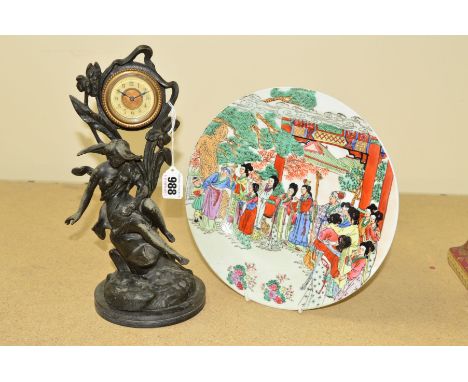 A SMALL ART NOUVEAU STYLE SPELTER CLOCK, a female figure perched upon a rock, surrounded by stylised plants, the clock having