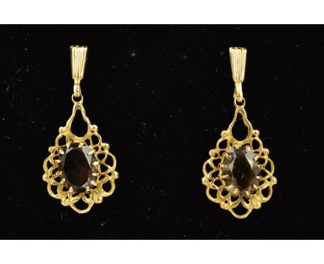 A PAIR OF 9CT GOLD SMOKEY QUARTZ DROP EARRINGS, each designed with a central oval smokey quartz within claw settings to the o