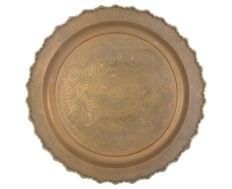 A Vintage Chinese import brass charger, with shaped edge and engraved decoration depicting a dragon, 74cm