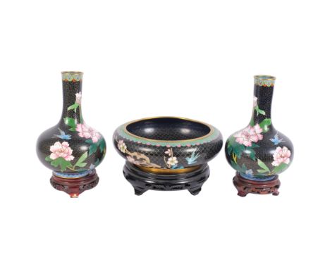 A pair of Chinese black ground cloisonne enamel vases, with enamelled floral decoration, on carved hardwood stands, H22cm, an