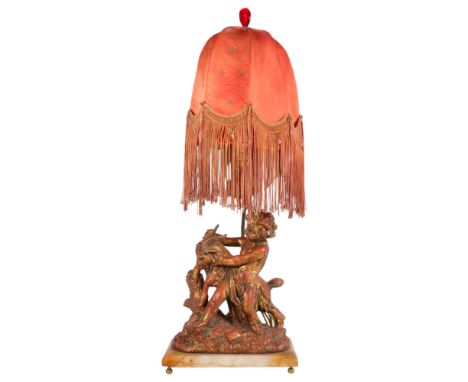 An early 20th century painted and gilded spelter lamp, modelled as a cherub and goat, on alabaster plinth, with fringed silk 