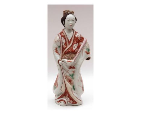 A Japanese Imari/Kutani Figure of a serving girl wearing traditional dress (hair comb repaired), clutching her robe in her ri